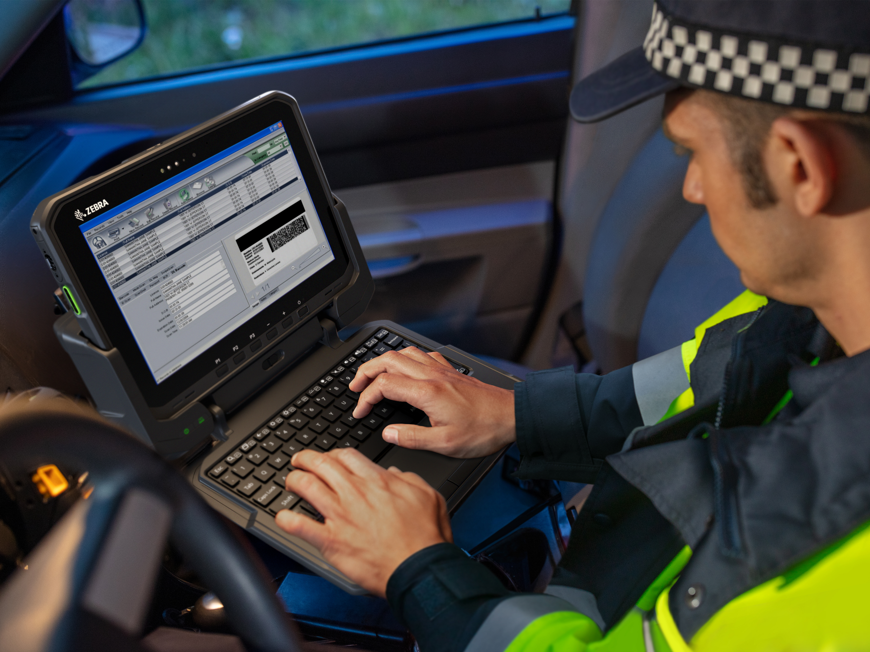 Police officer typing on keyboard in car Police officer typing on keyboard in car