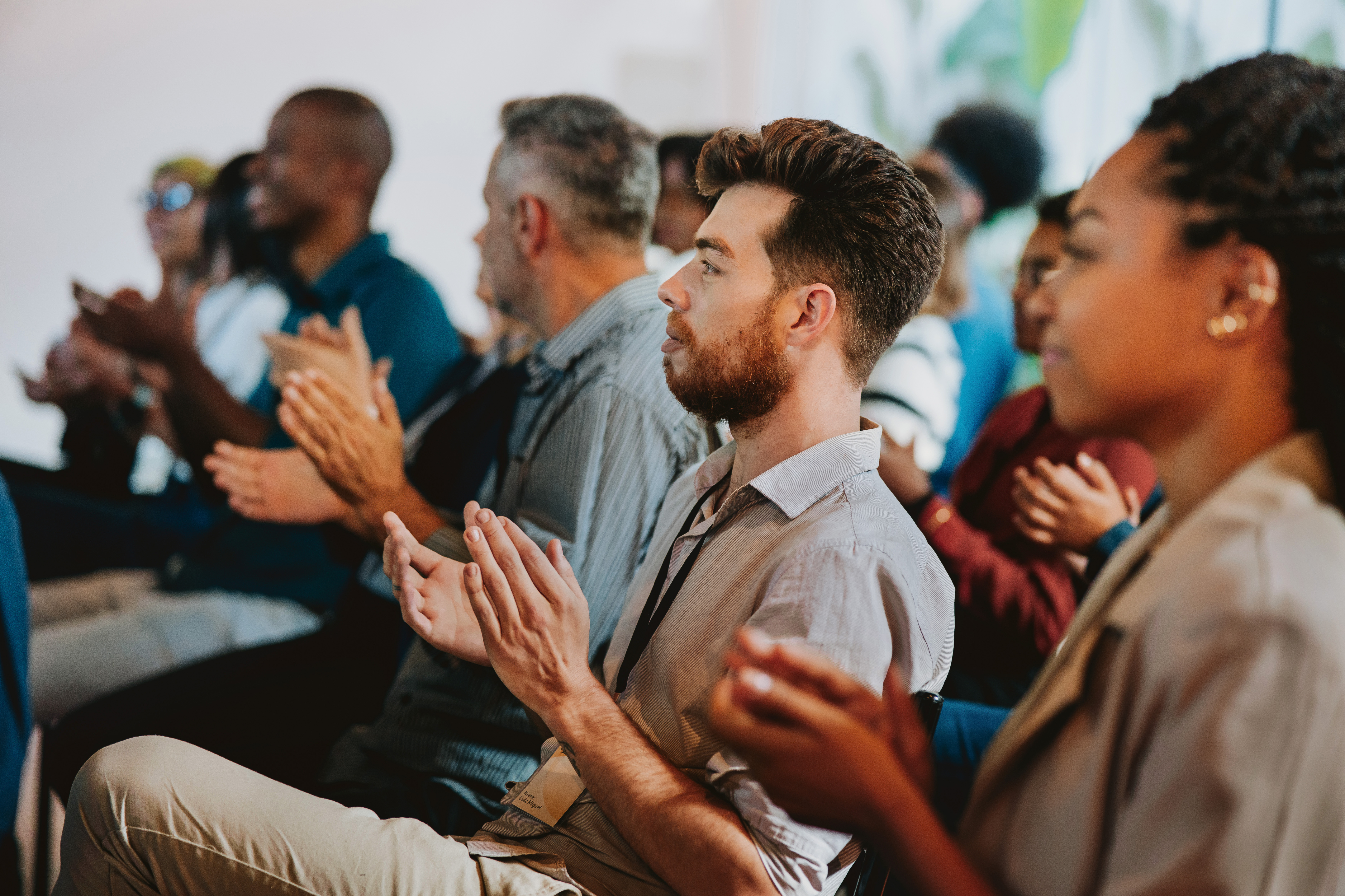 An audience applauding during a presentation. An audience applauding during a presentation.