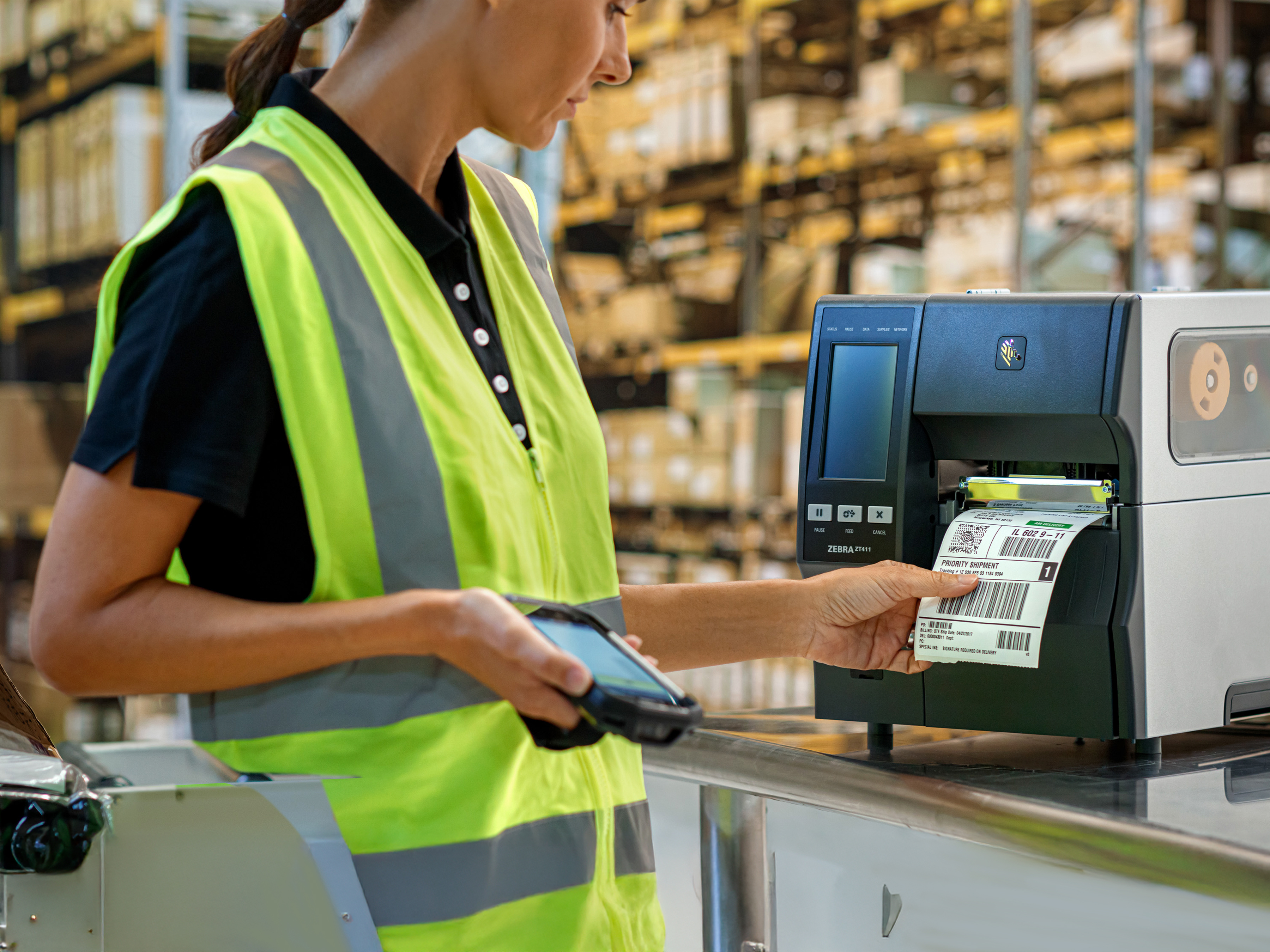 Fulfillment Worker using a Zebra industrial printer to print a shipping label.  Fulfillment Worker using a Zebra industrial printer to print a shipping label.