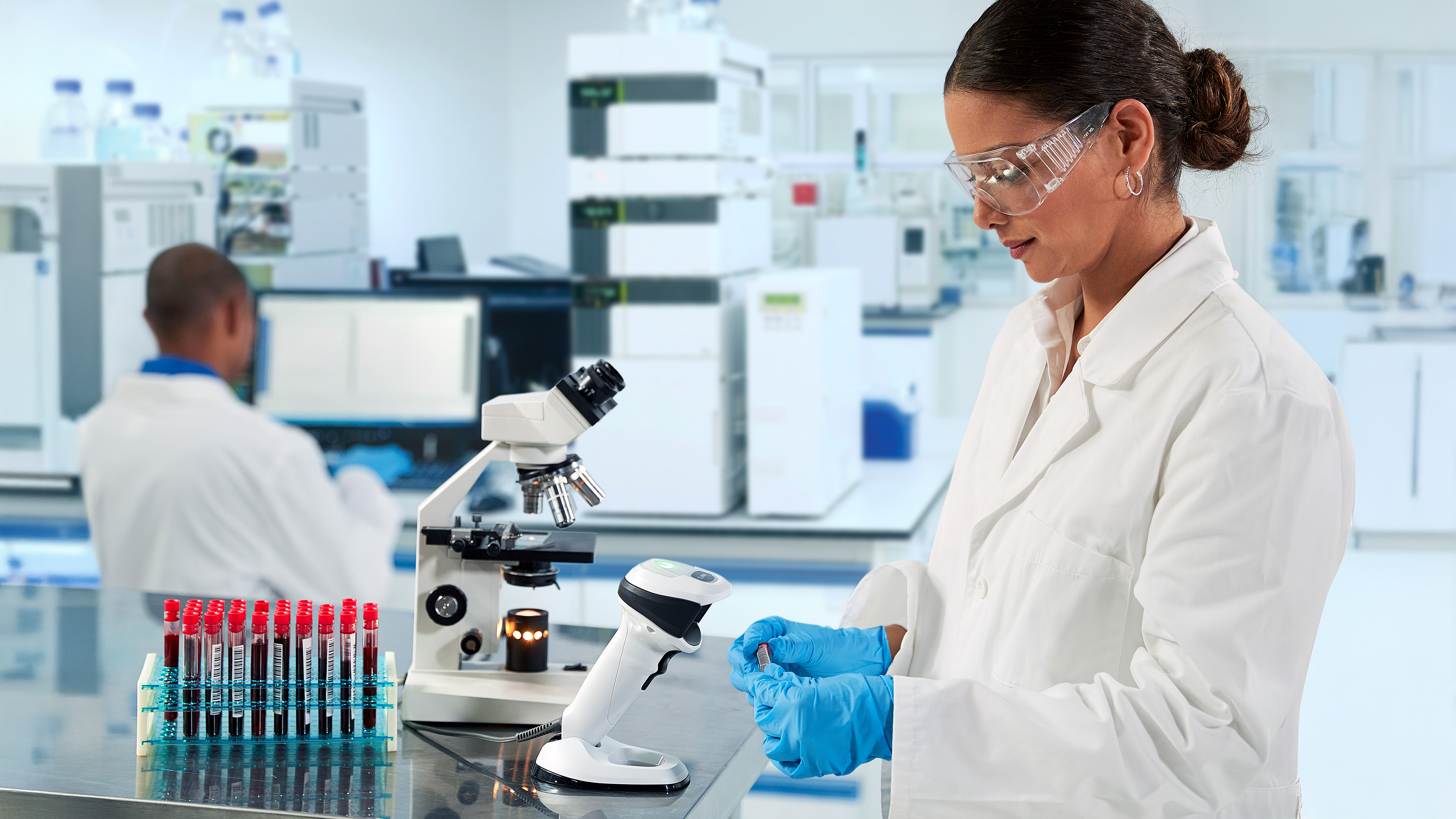 Laboratory worker in goggles doing a research using a microscope Laboratory worker in goggles doing a research using a microscope