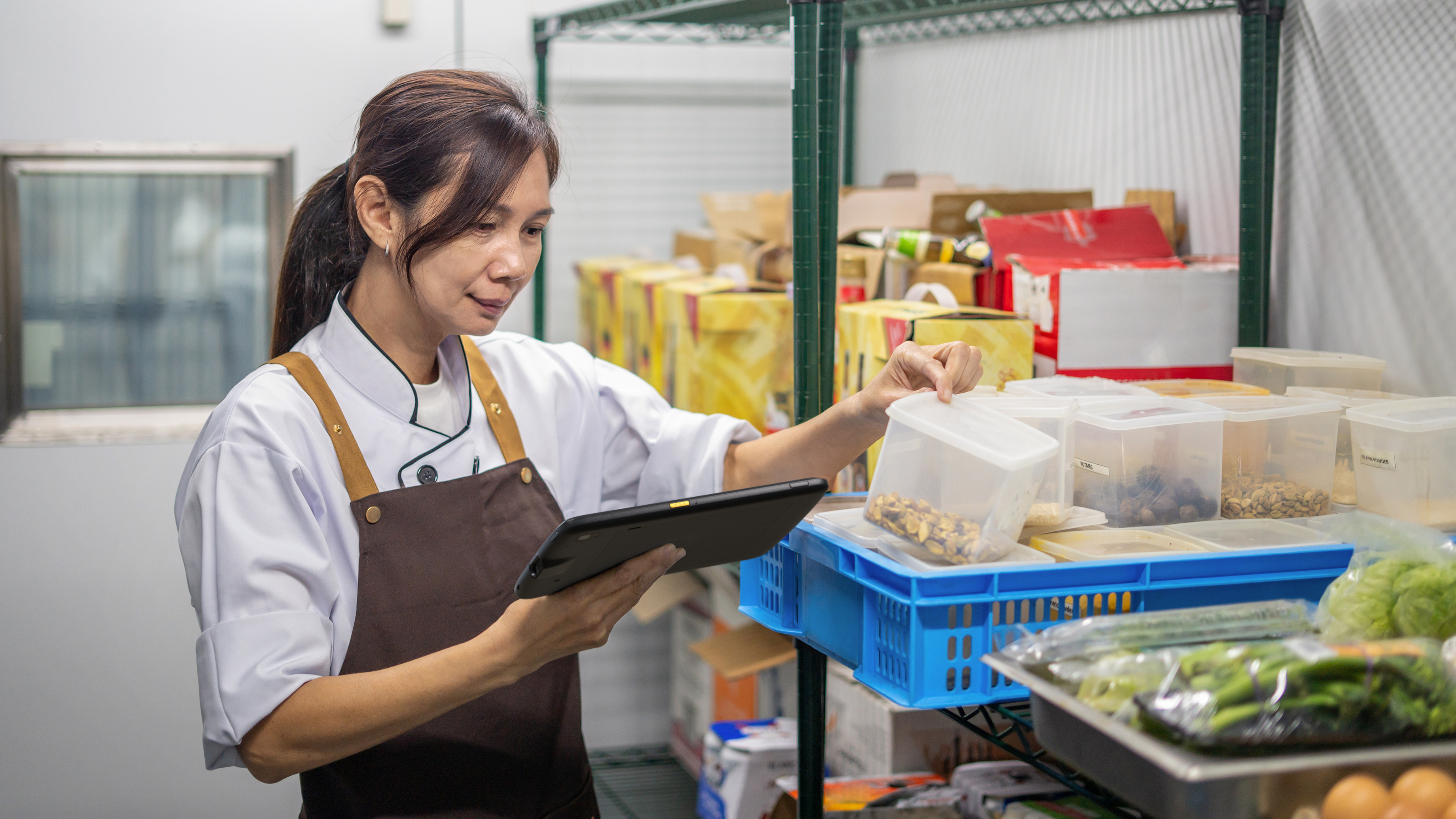 Hospitality worker checking food inventory with a Zebra tablet Hospitality worker checking food inventory with a Zebra tablet