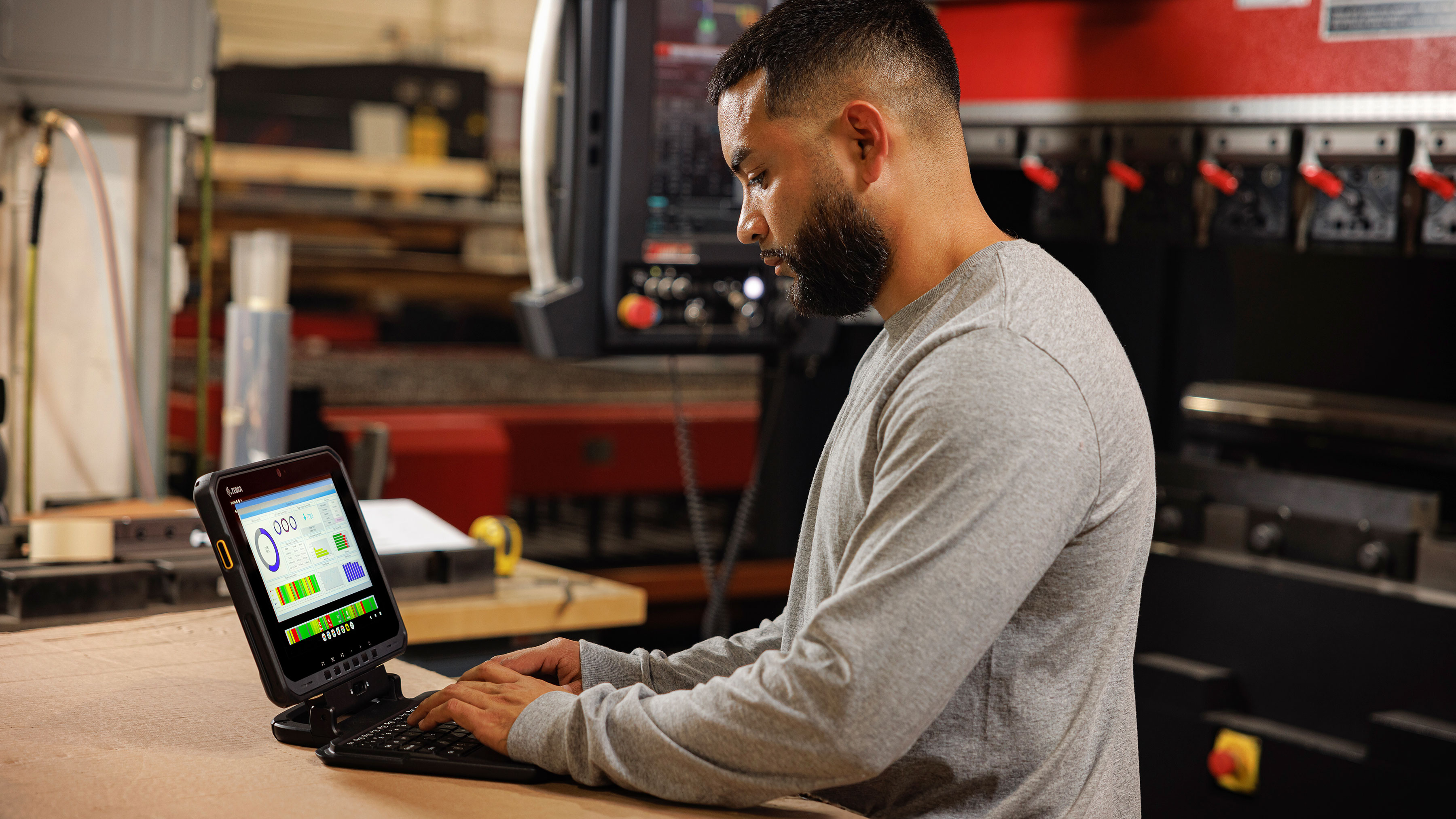 Employee using a Zebra tablet in a manufacturing setting. Employee using a Zebra tablet in a manufacturing setting.