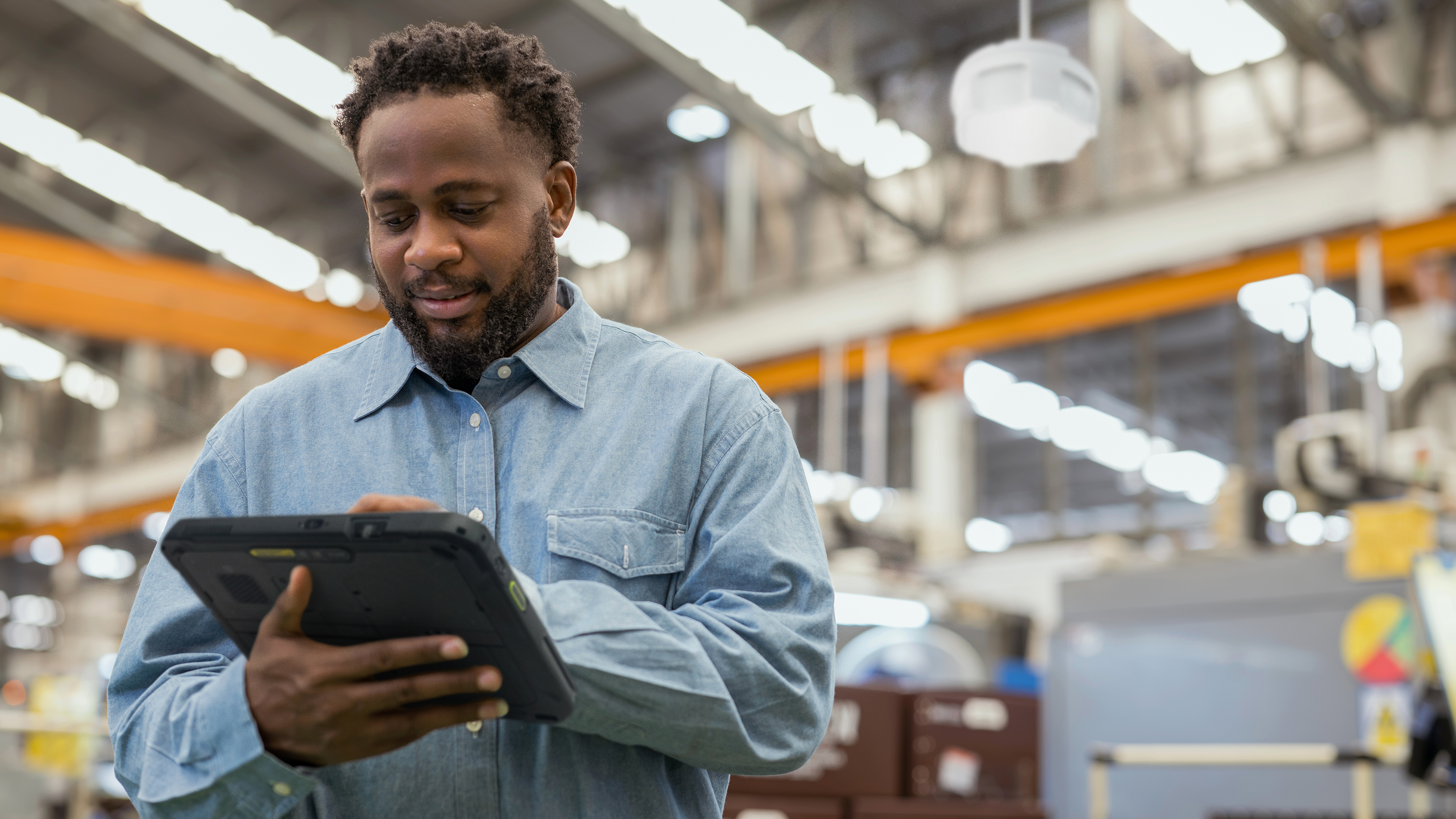 Manufacturing worker using a Zebra rugged tablet on factory floor. Manufacturing worker using a Zebra rugged tablet on factory floor.