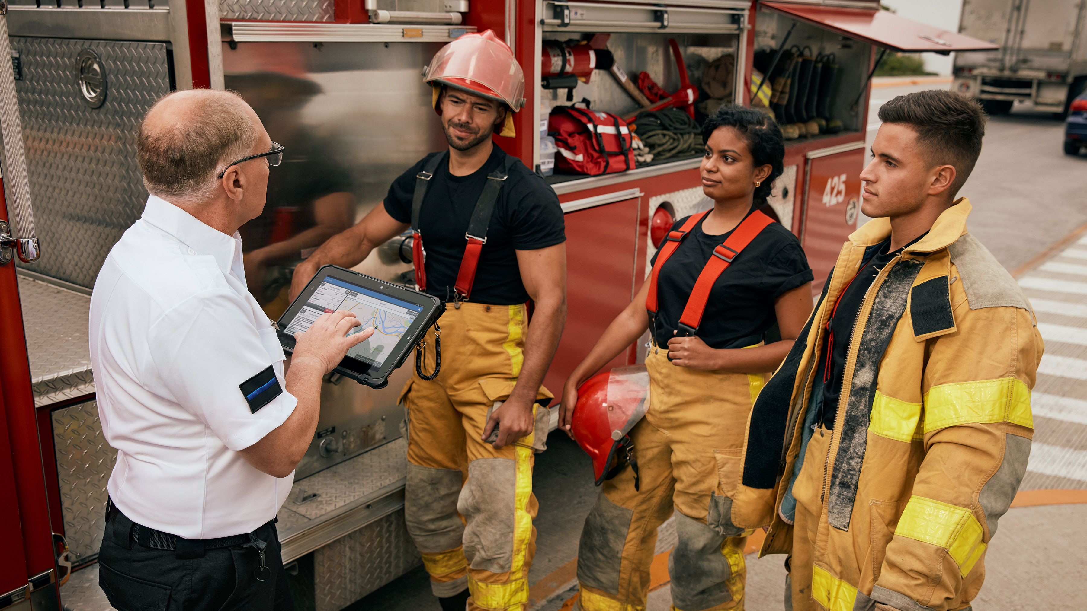 Firefighters and fire chief having a meeting with a Zebra rugged tablet. Firefighters and fire chief having a meeting with a Zebra rugged tablet.