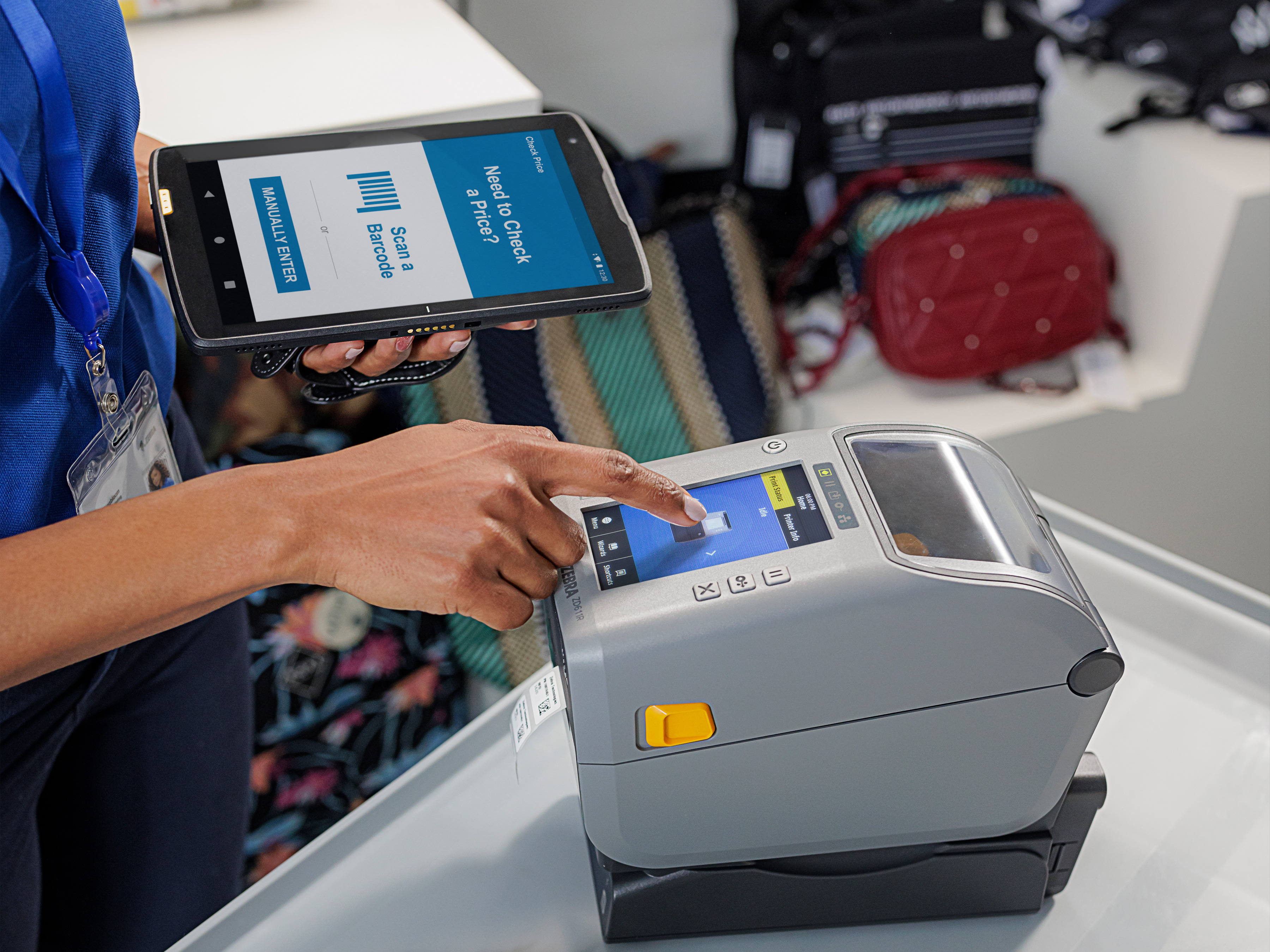 Retail worker using a tablet to print a label with a Zebra desktop printer. Retail worker using a tablet to print a label with a Zebra desktop printer.