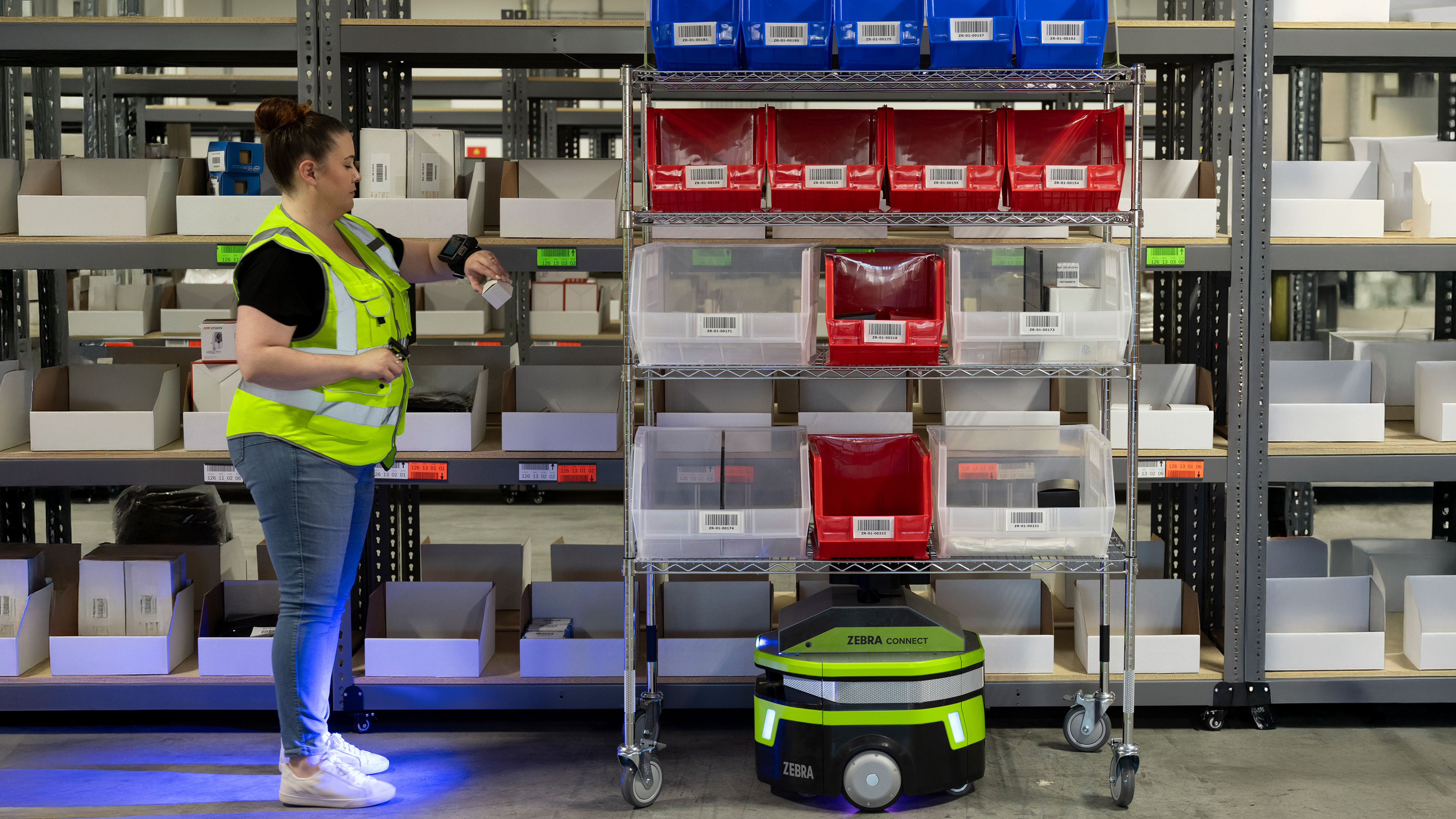 Zebra mobile robot next to an employee scanning item on the shelves Zebra mobile robot next to an employee scanning item on the shelves