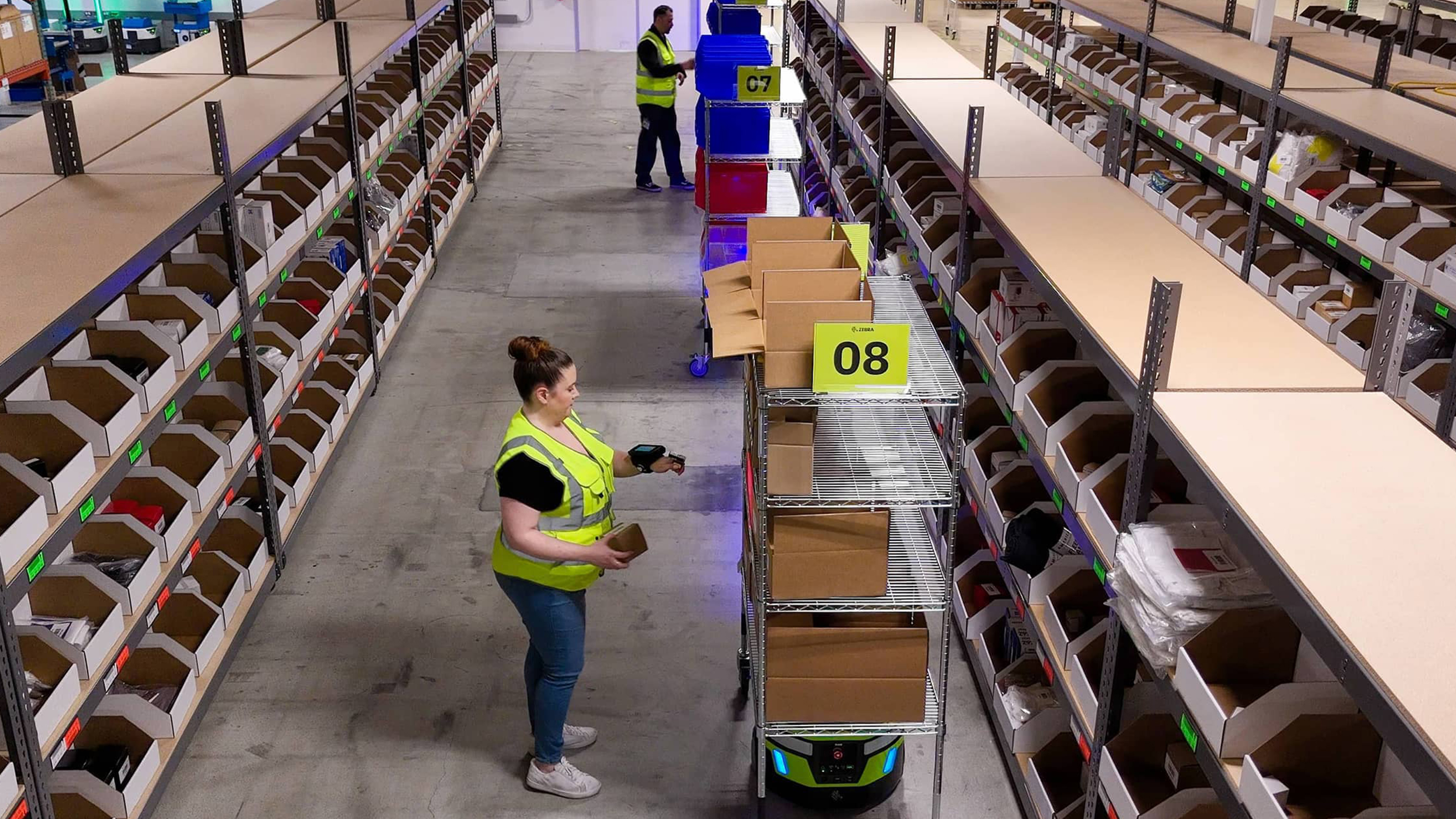 Warehouse staffs scanning boxes on Zebra mobile robot Warehouse staffs scanning boxes on Zebra mobile robot