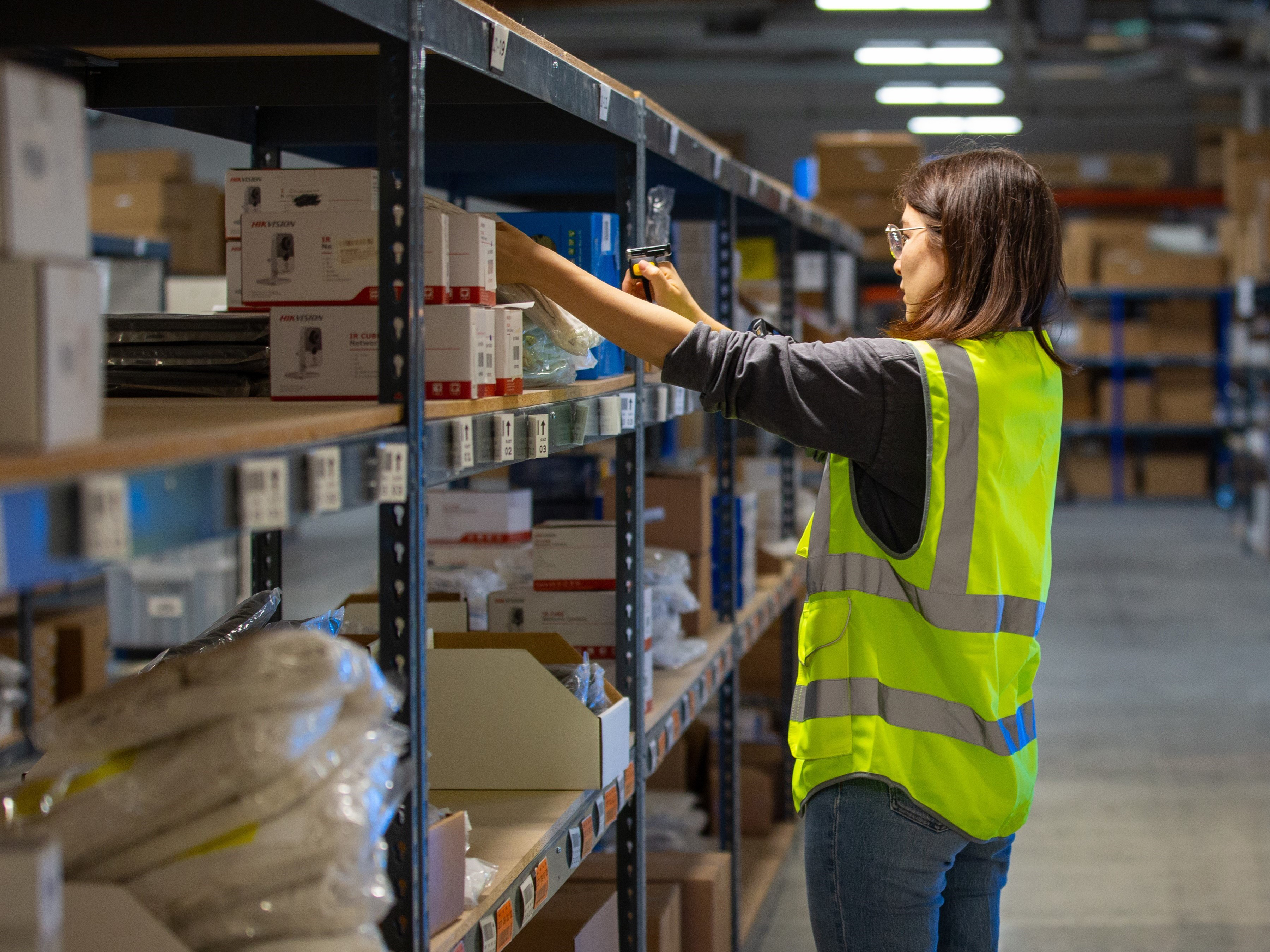 Warehouse worker packing boxes on the shelves at a warehouse Warehouse worker packing boxes on the shelves at a warehouse