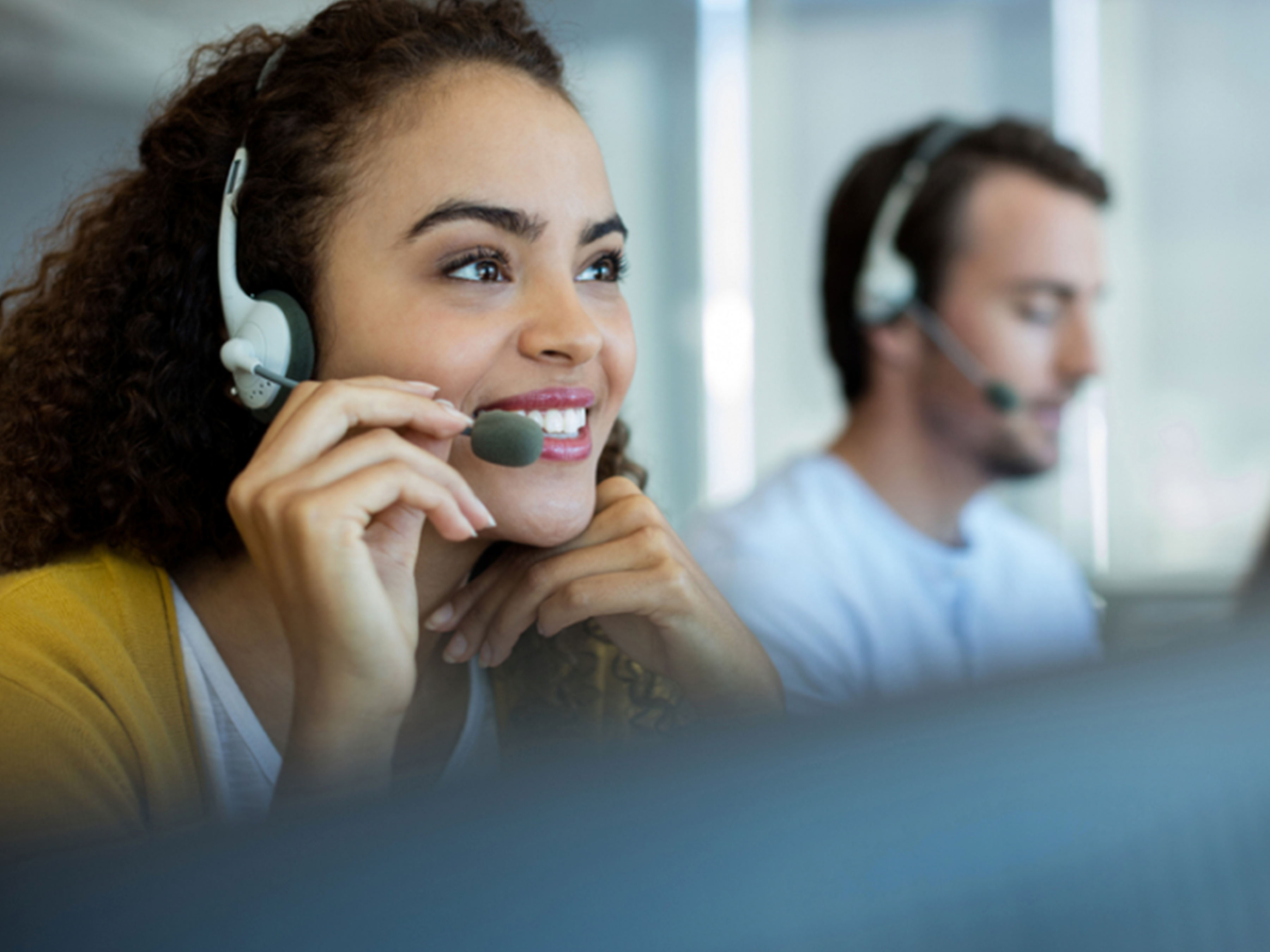 Customer service representatives using headphones in an office setting. Customer service representatives using headphones in an office setting.