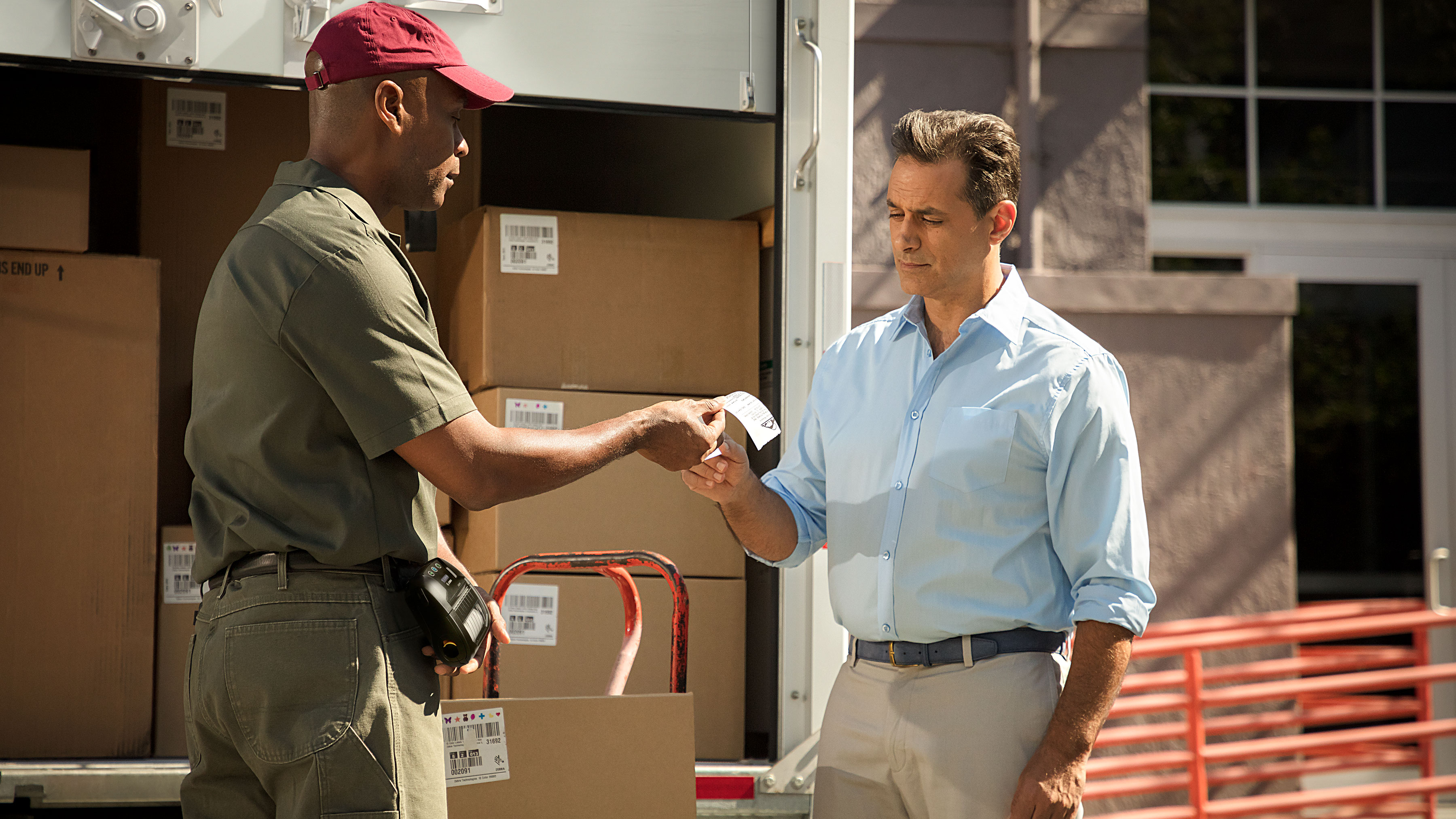 Delivery personnel giving a customer a receipt that was printed on a Zebra mobile printer. Delivery personnel giving a customer a receipt that was printed on a Zebra mobile printer.