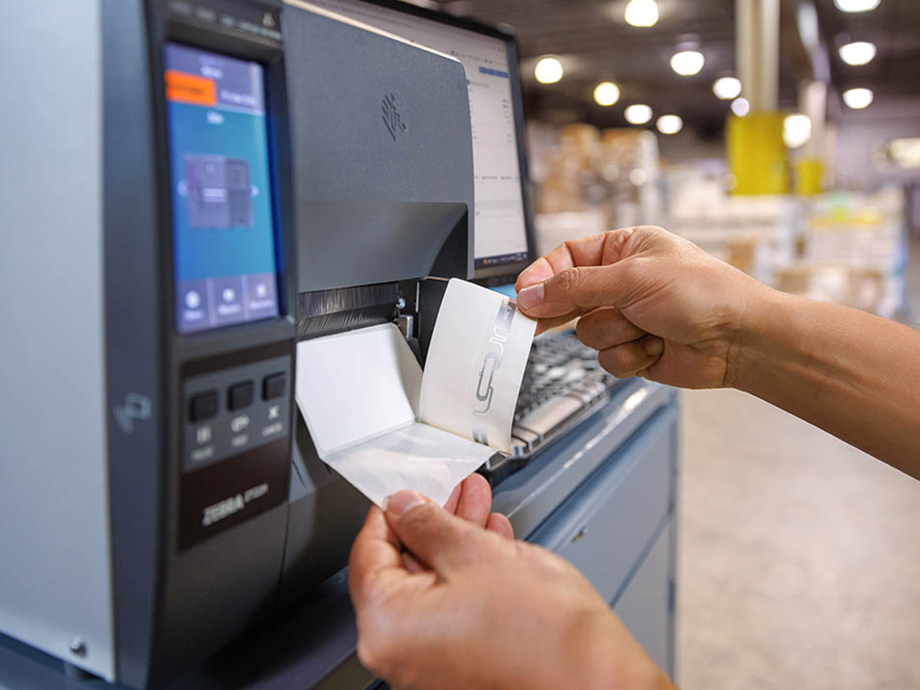 Warehouse worker printing a label using a Zebra industrial printer. Warehouse worker printing a label using a Zebra industrial printer.
