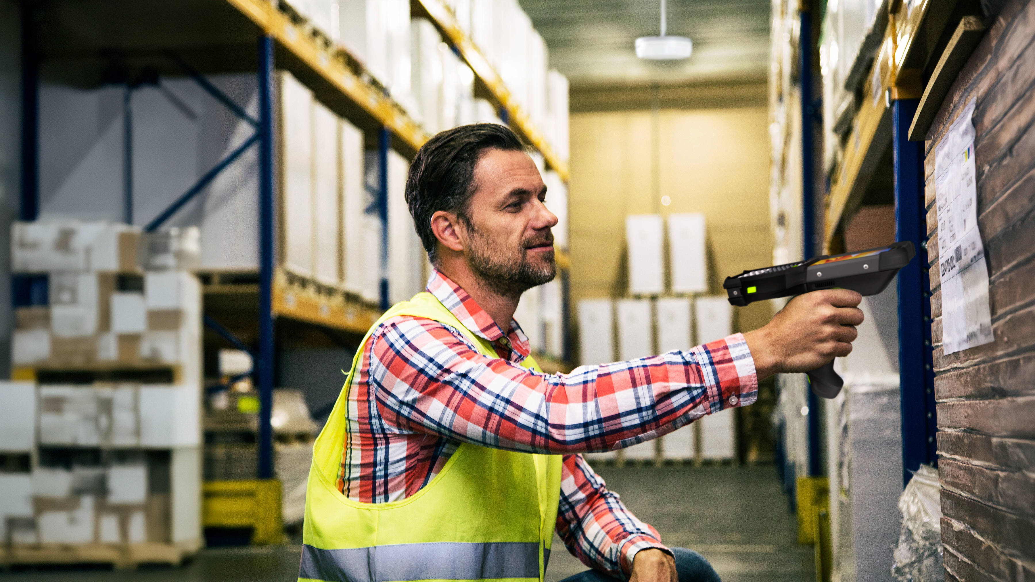 Warehouse worker scanning pallet label using a Zebra mobile computer Warehouse worker scanning pallet label using a Zebra mobile computer