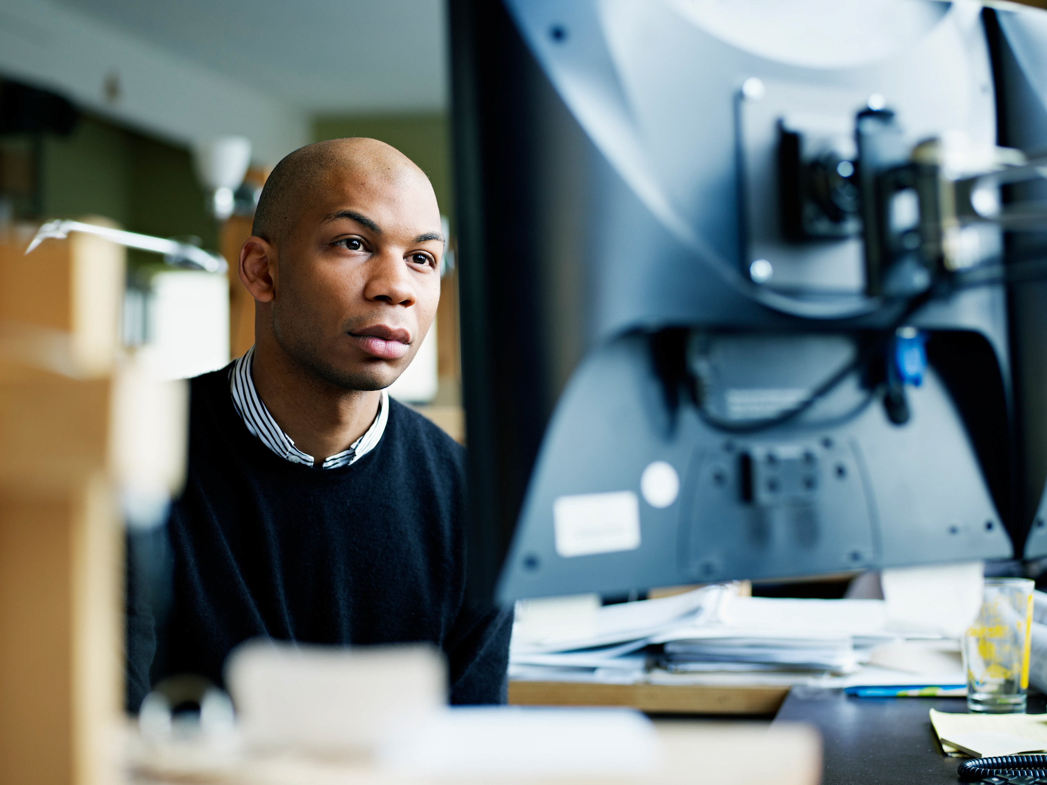 A focused employee working on a computer inside an office setting. A focused employee working on a computer inside an office setting.
