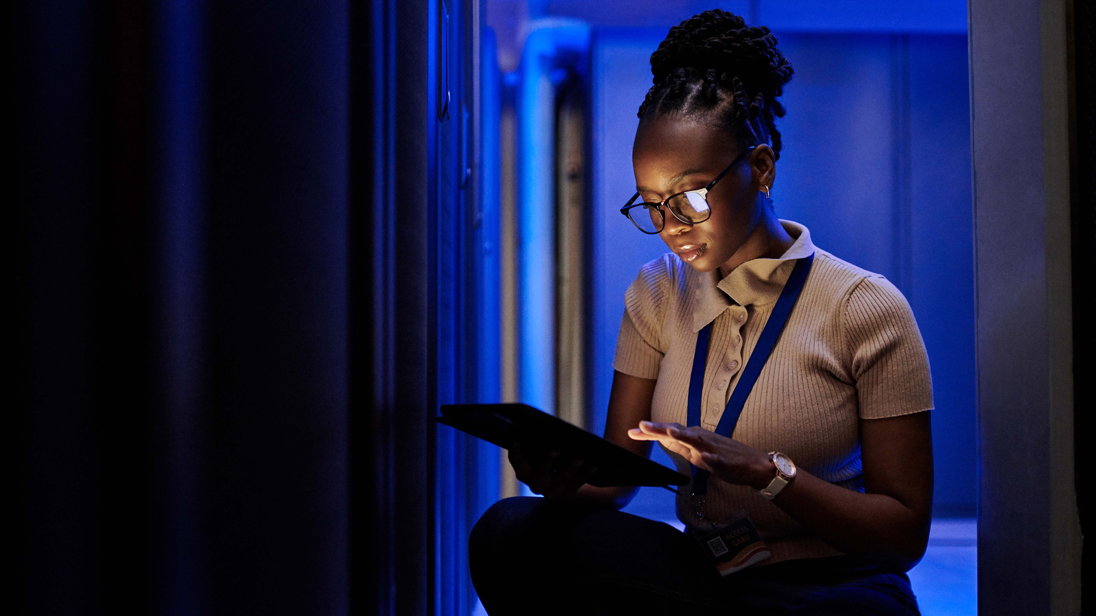 An IT professional is using a tablet to monitor and manage the server racks. An IT professional is using a tablet to monitor and manage the server racks.