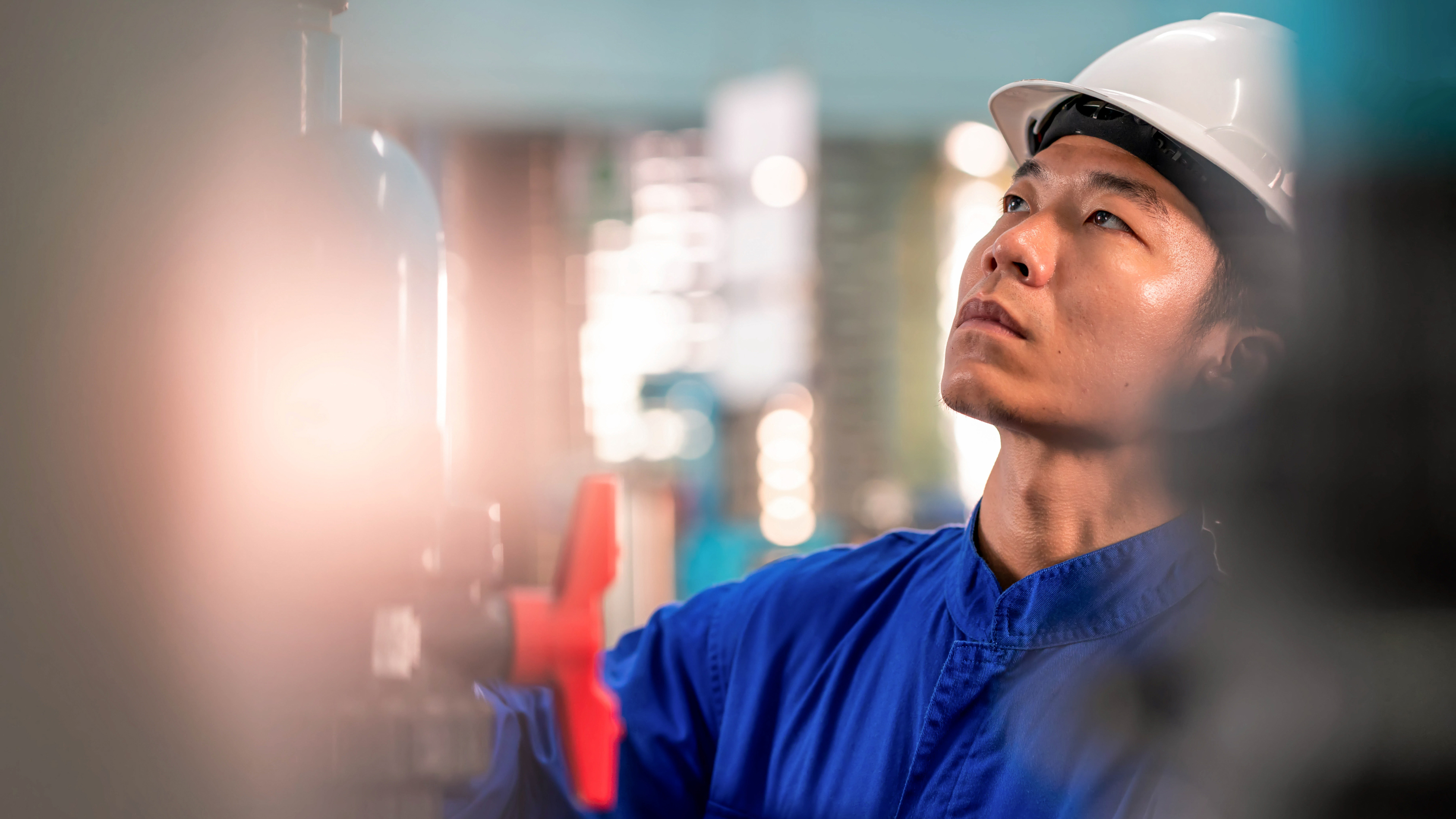 An industrial worker examining equipment for maintenance. An industrial worker examining equipment for maintenance.