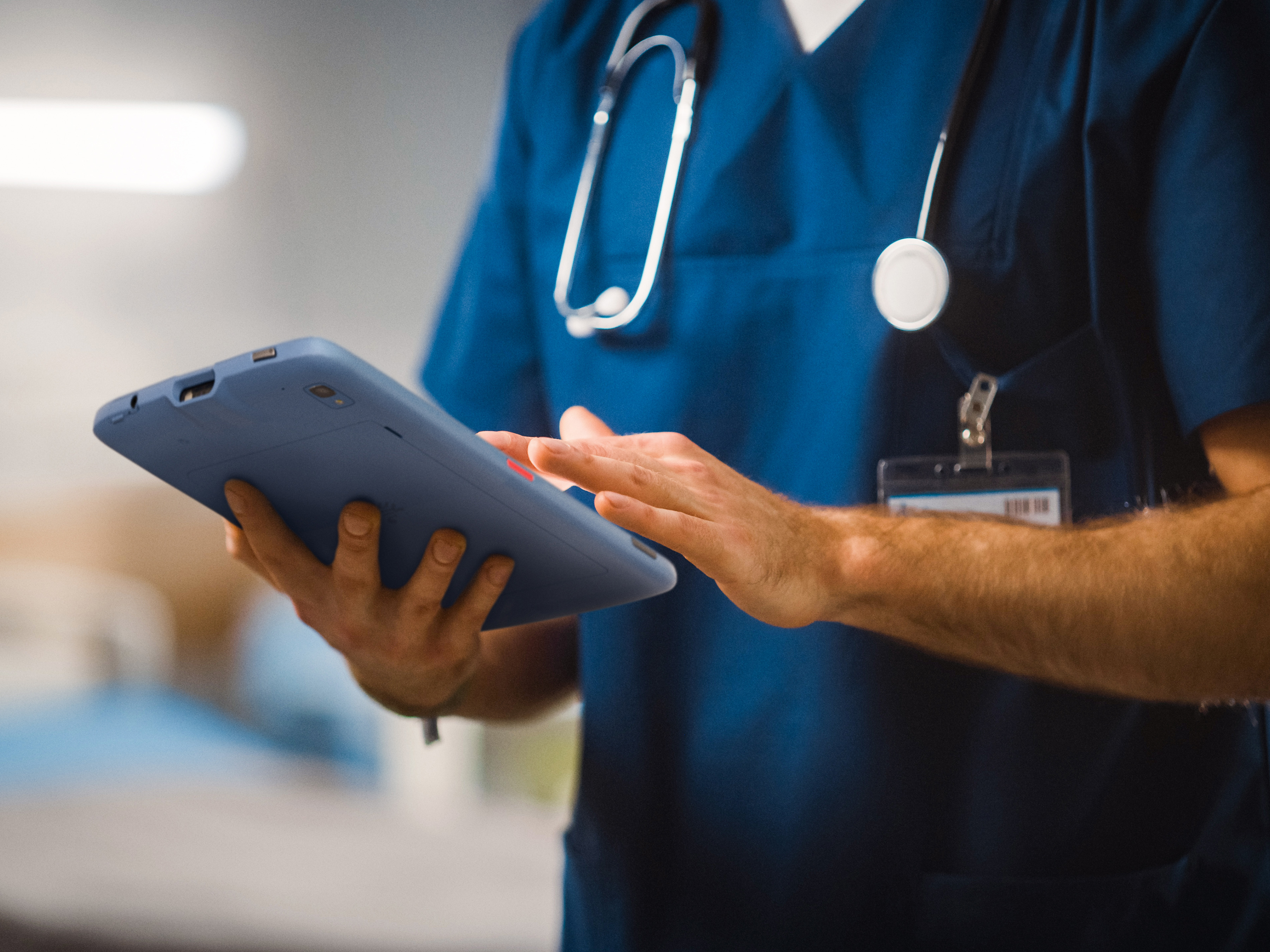 A medical professional using a Zebra tablet inside of a hospital. A medical professional using a Zebra tablet inside of a hospital.
