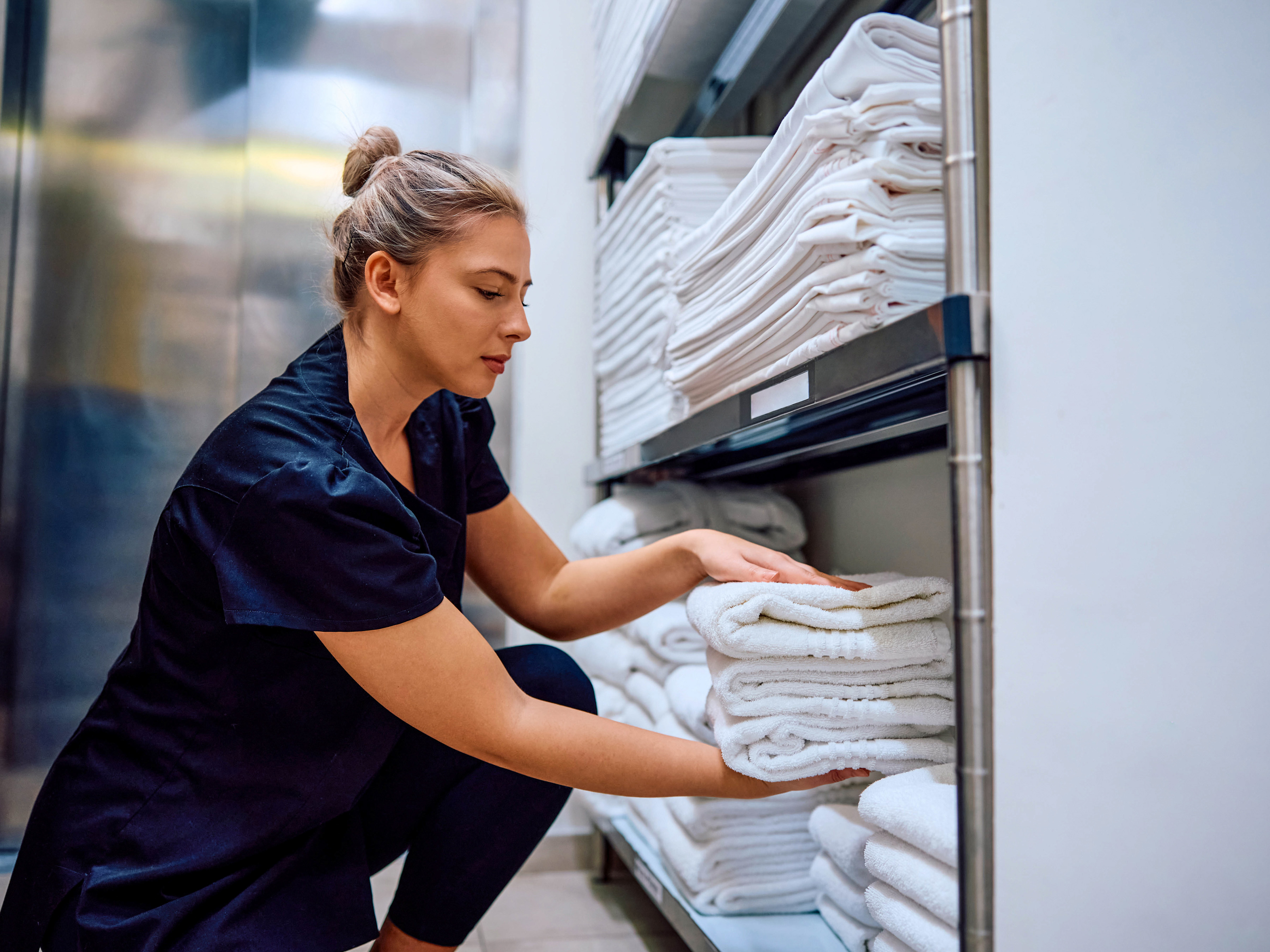 Housekeeping getting towels from a storage room inside of a hotel. Housekeeping getting towels from a storage room inside of a hotel.