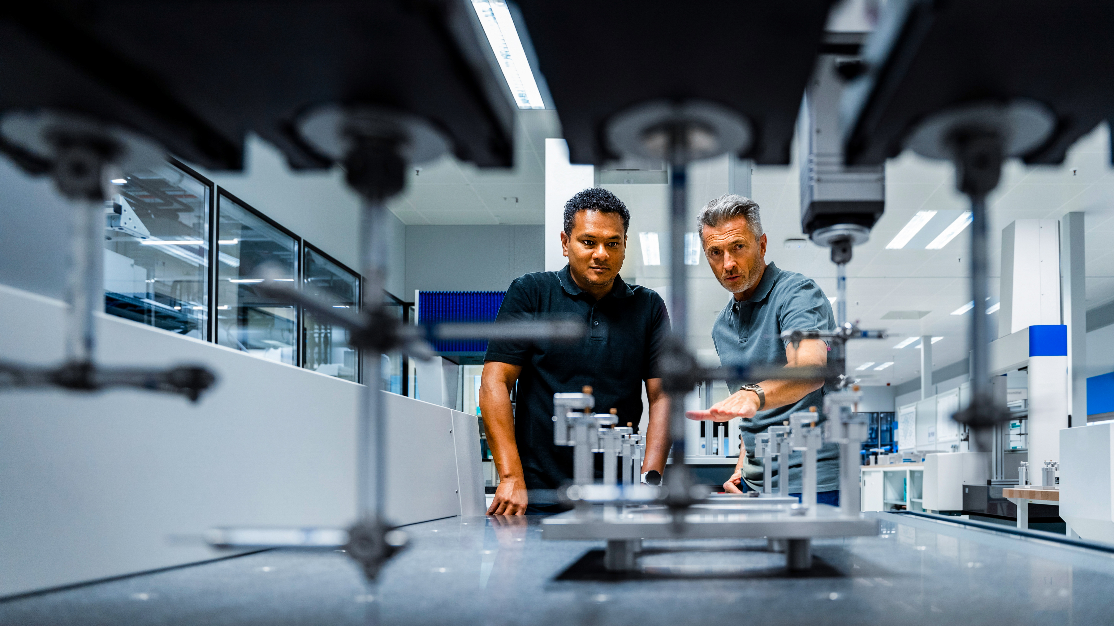 Two engineers are inspecting and discussing machinery in a modern industrial setting. Two engineers are inspecting and discussing machinery in a modern industrial setting.