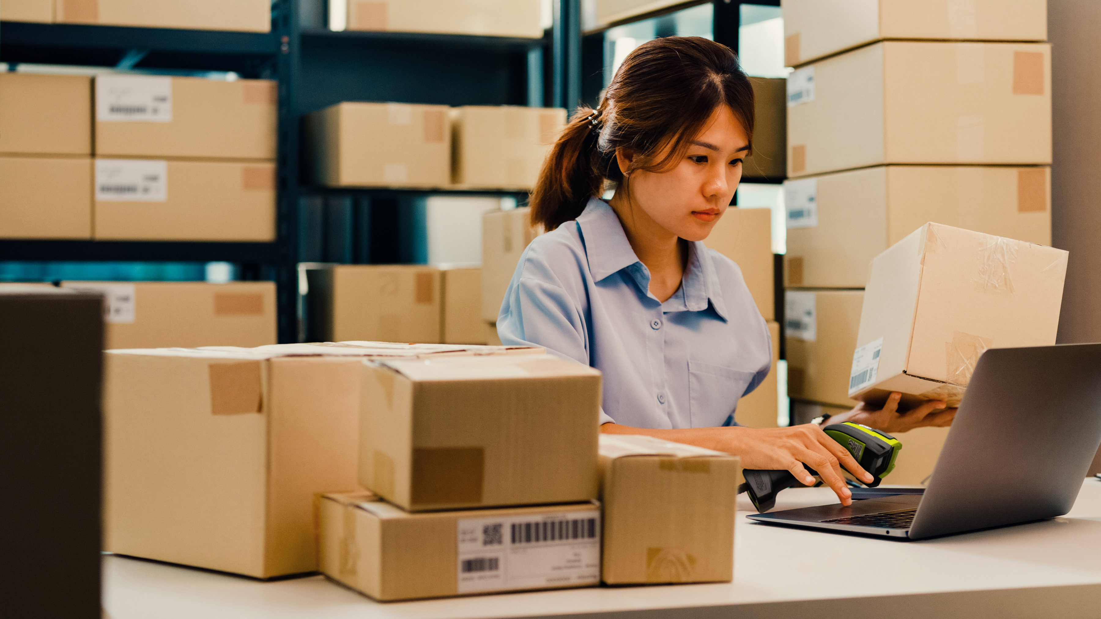 An employee handling box deliveries using a Zebra handheld barcode scanner. An employee handling box deliveries using a Zebra handheld barcode scanner.