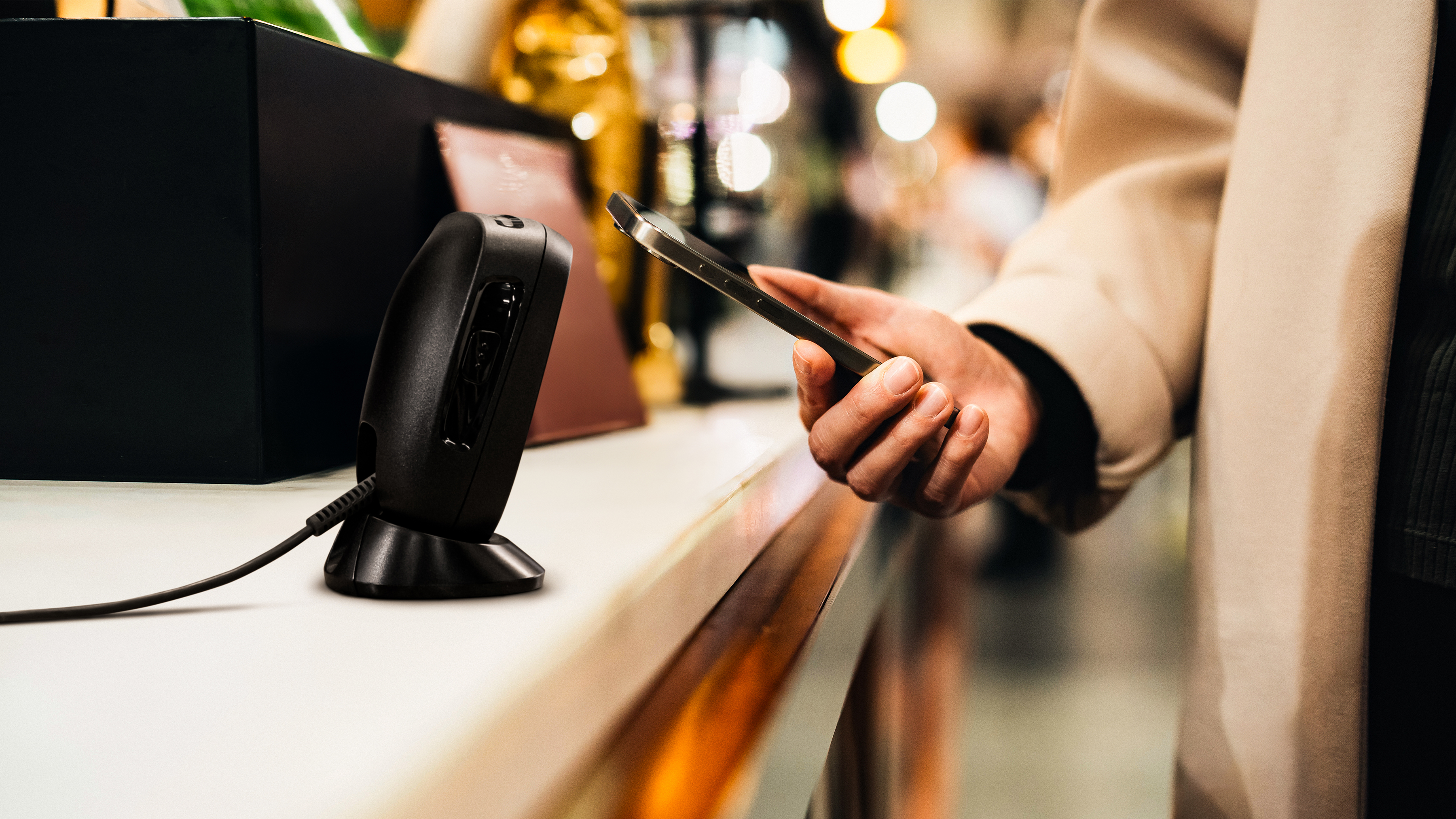 A shopper using tap-to-pay at checkout inside of a retail store. A shopper using tap-to-pay at checkout inside of a retail store.
