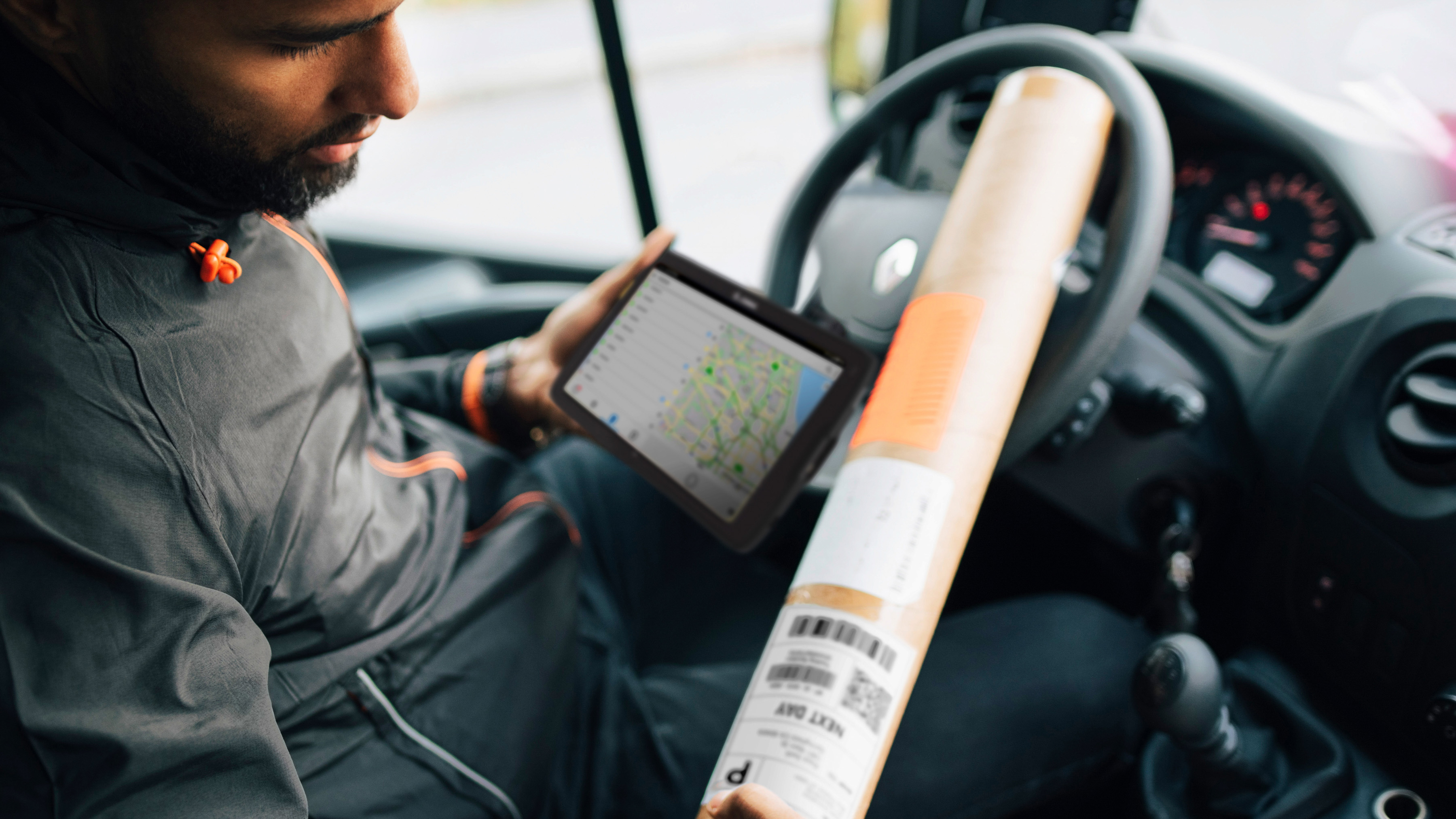 Courier in a delivery vehicle using a Zebra tablet. Courier in a delivery vehicle using a Zebra tablet.