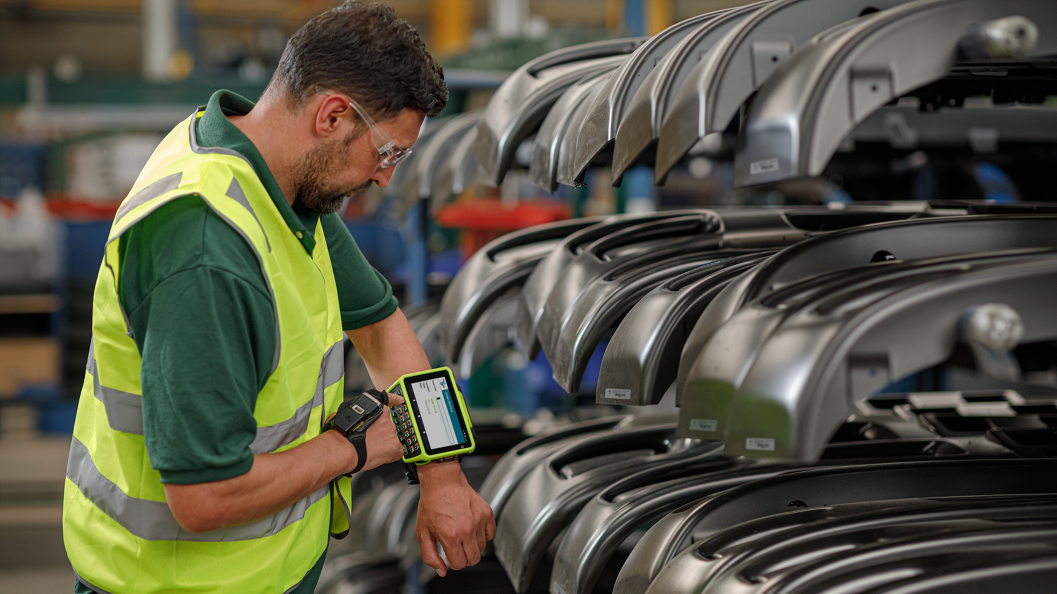 WT6400 Photgraphy Website Manufacturing RS5200 Assembly 16x9 Assembly worker using Zebra WT6400 and RS5100 wearable mobile computers to select parts via barcode scanning.